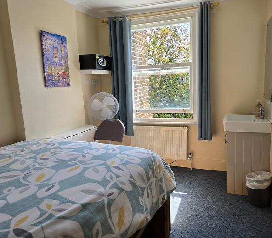 cozy bedroom with a bed and sink natural light from the window 4 comfortable living space